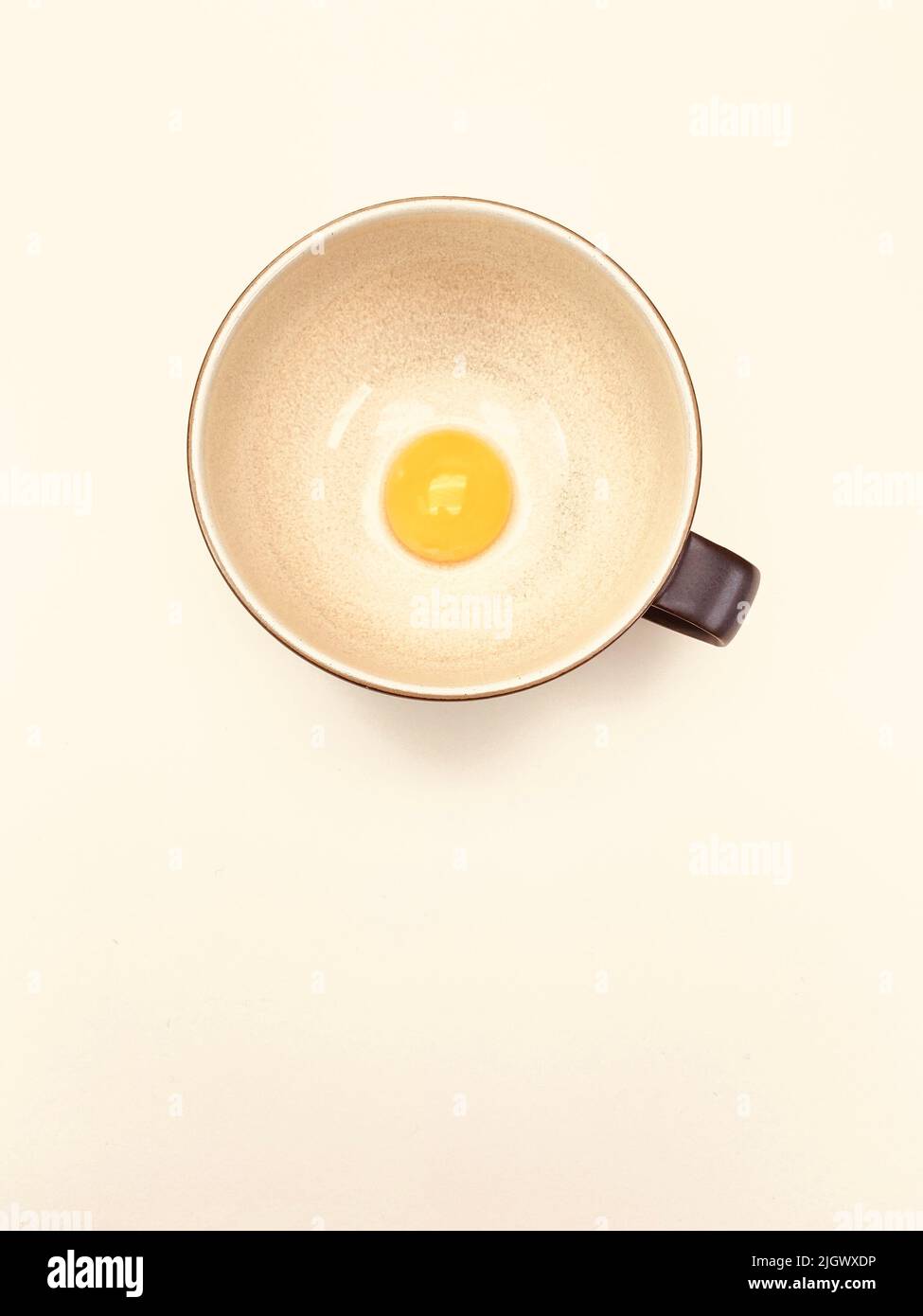 bowl with egg jolt on a beige table Stock Photo