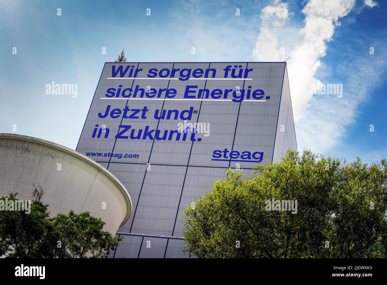 Herten Germany, July 12, 2022: Inscription *'We ensure safe energy. Now and in the future'* on a block of the STEAG cogeneration plant in Herten promises safe energy for the future through hard coal. The Herne combined heat and power plant only has one block in which not only electricity but also district heating for the Ruhr district heating network is generated from hard coal. Stock Photo