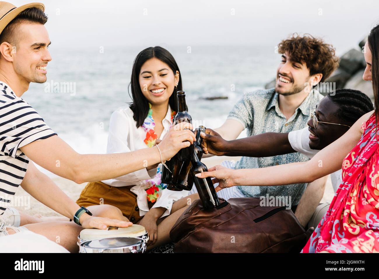Multiracial friends cheering with beer at summer party at beach Stock Photo