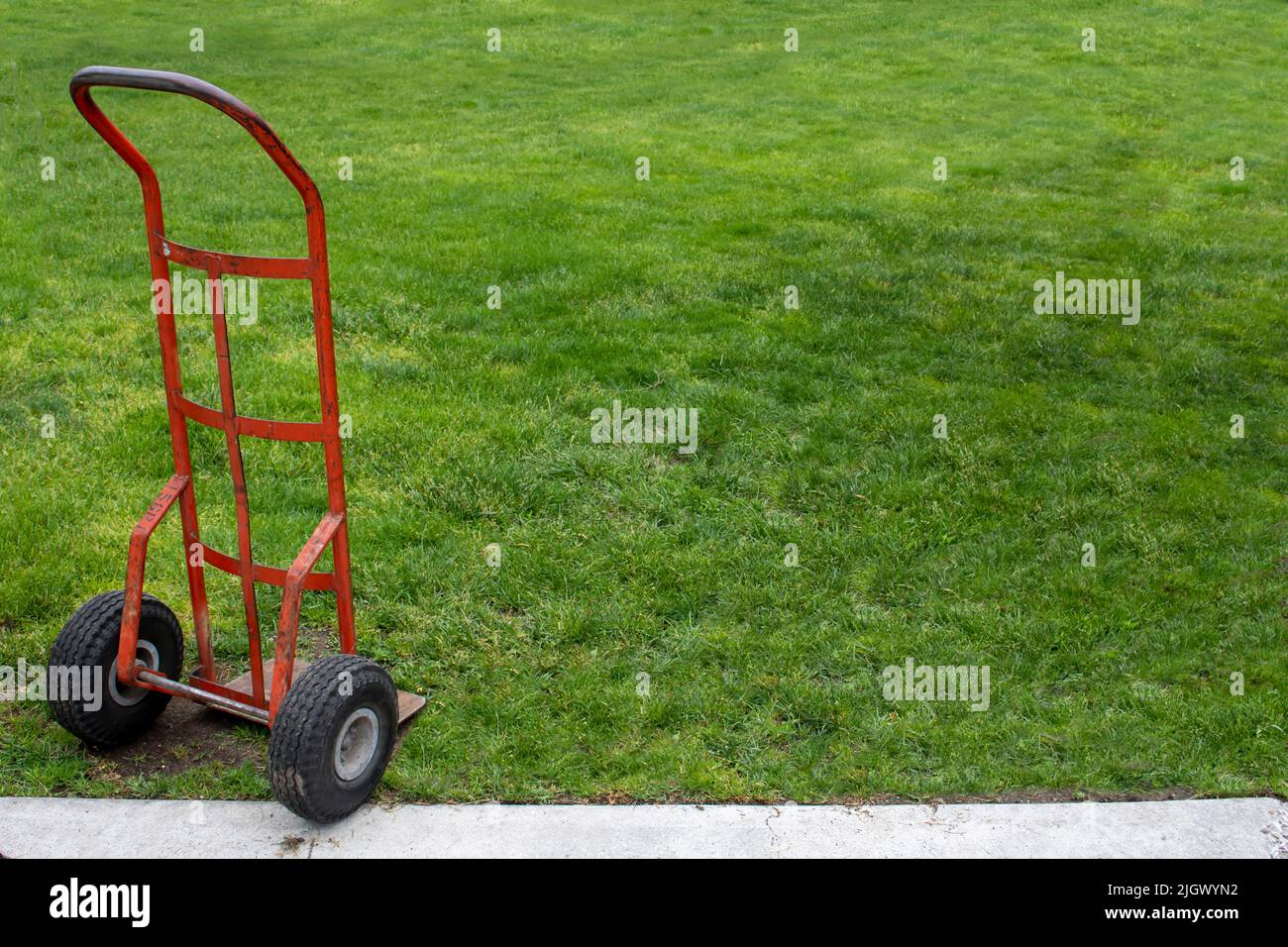 Rubber tire metal hand cart to move boxes and other itemas on a green