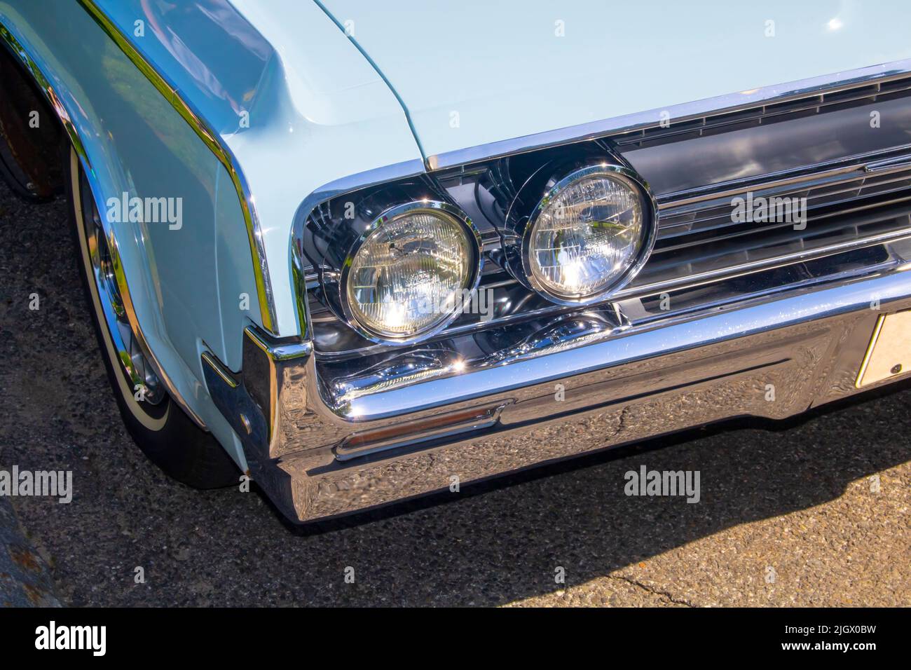close up of classic vintage aesthetic car front lights, grille, chrome bumper Stock Photo
