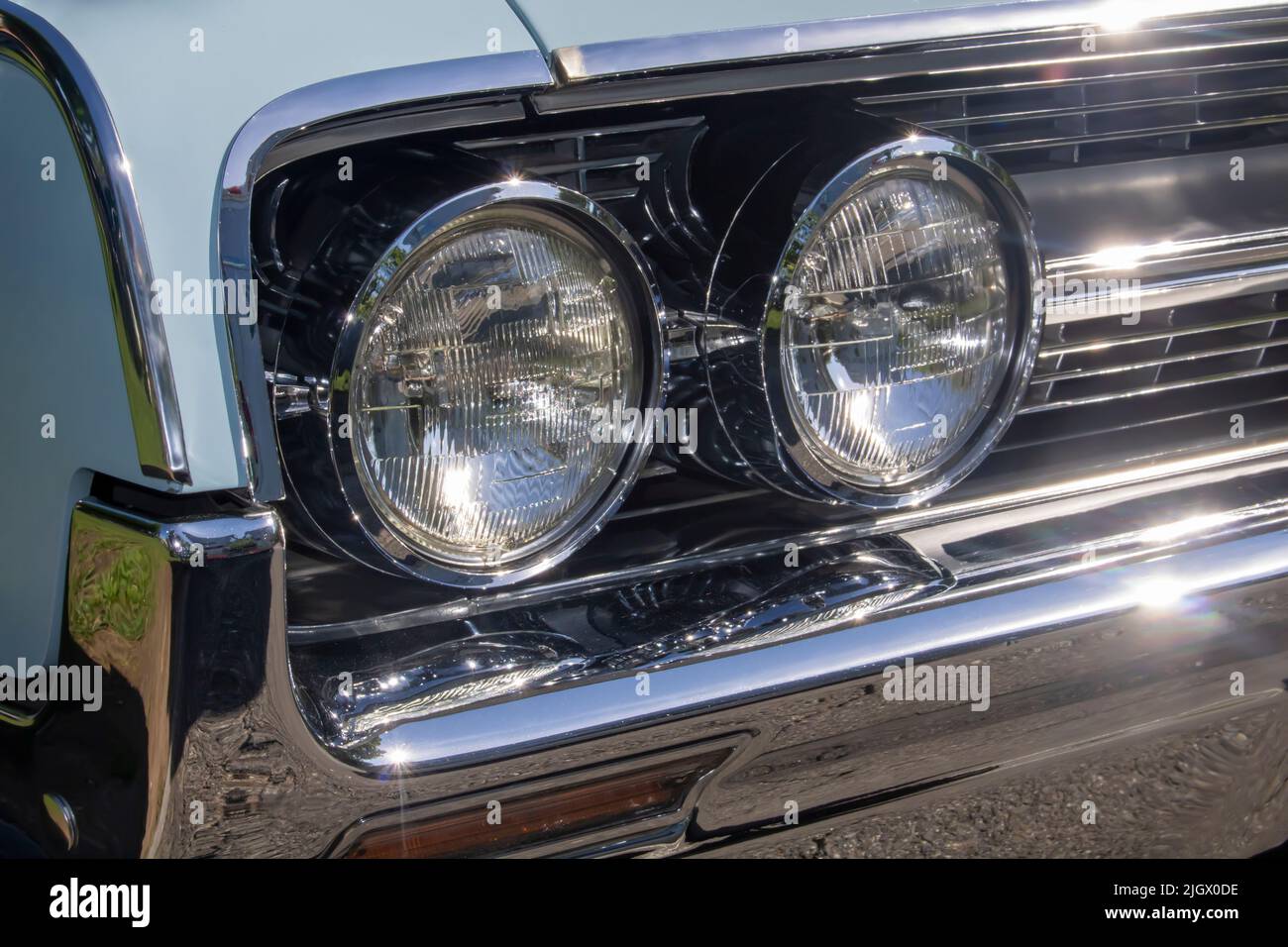 close up of classic vintage aesthetic car front lights, grille, chrome bumper Stock Photo
