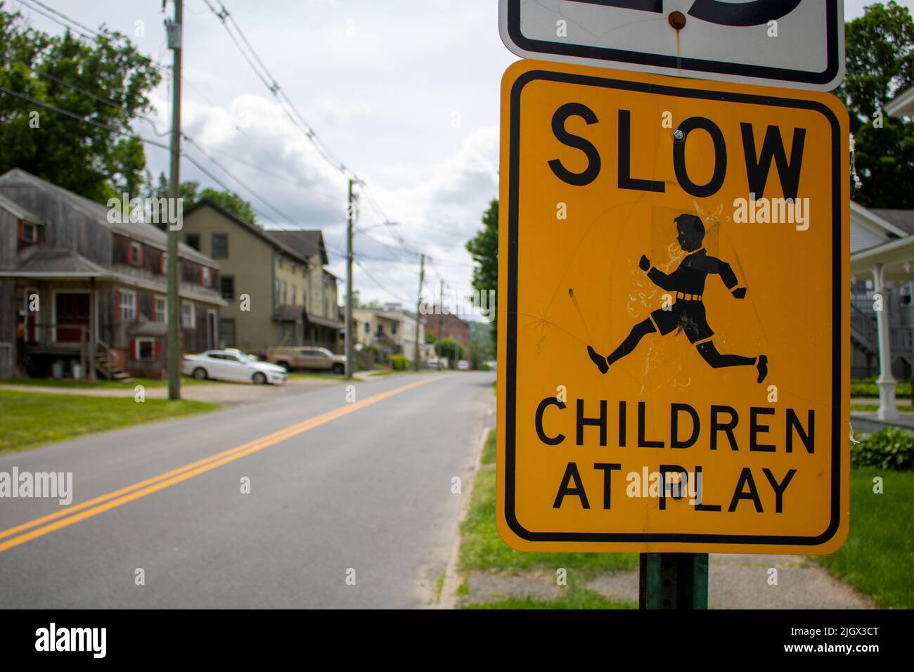 urban outdoor yellow black street sign with a message of Slow children at play icon of running boy Stock Photo