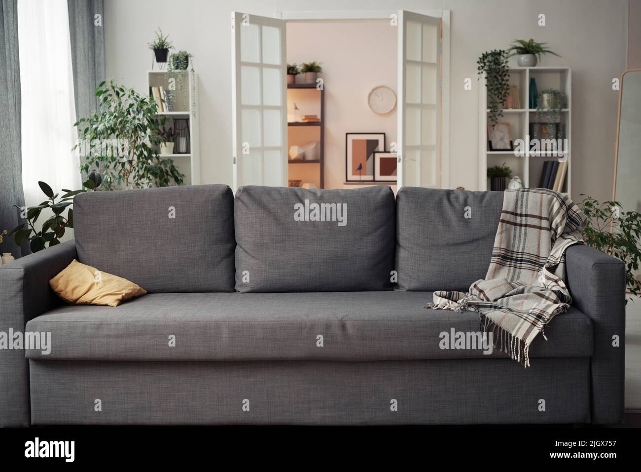 Horizontal image of comfortable big sofa standing in living room in apartment Stock Photo