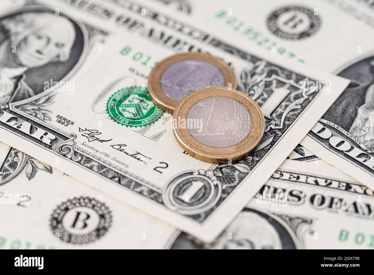 one Euro coins on US Dollar bills, parity and currency exchange rate concept Stock Photo