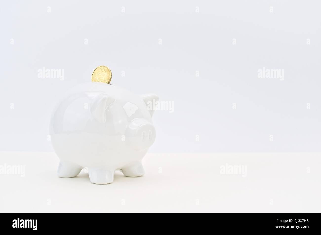 euro coin and white piggy bank on a white desk savings and inflation