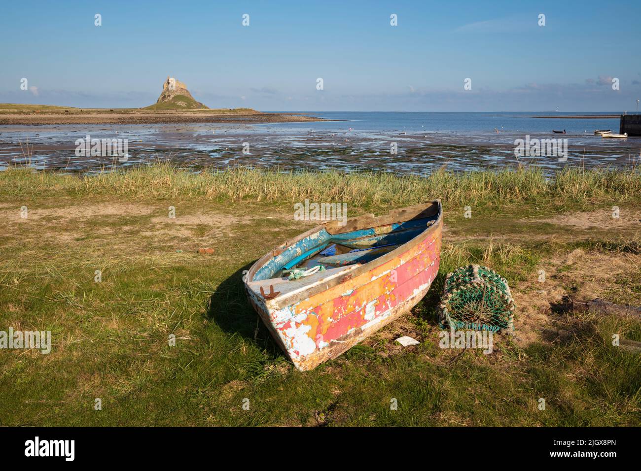 Old wooden boat on shore with Lindisfarne Castle at low tide, Holy Island, Northumberland, England, United Kingdom, Europe Stock Photo