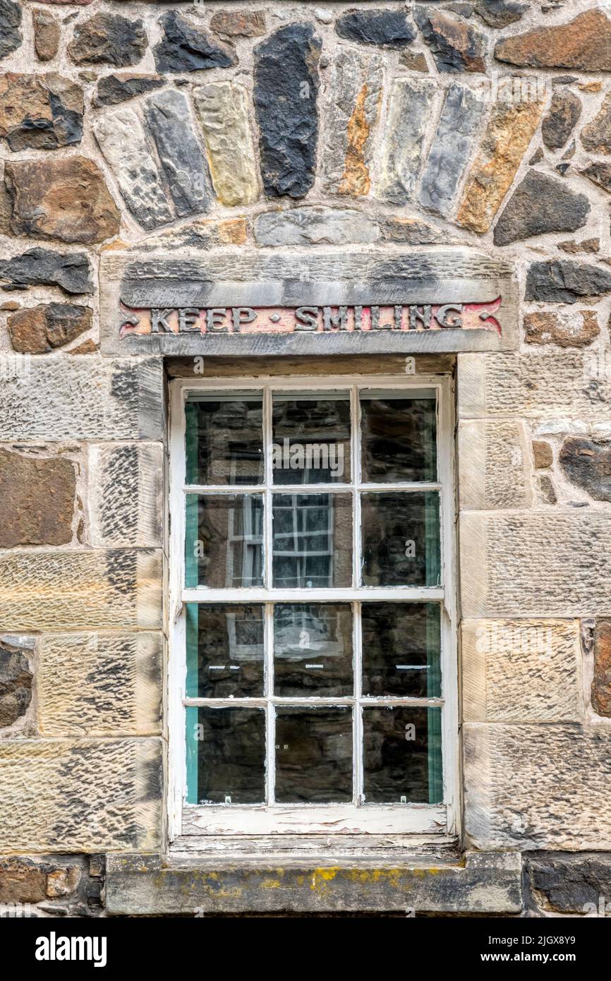 Keep Smiling motto carved above a window of the Boy's Club on St John Street in the old town of Stirling. Stock Photo