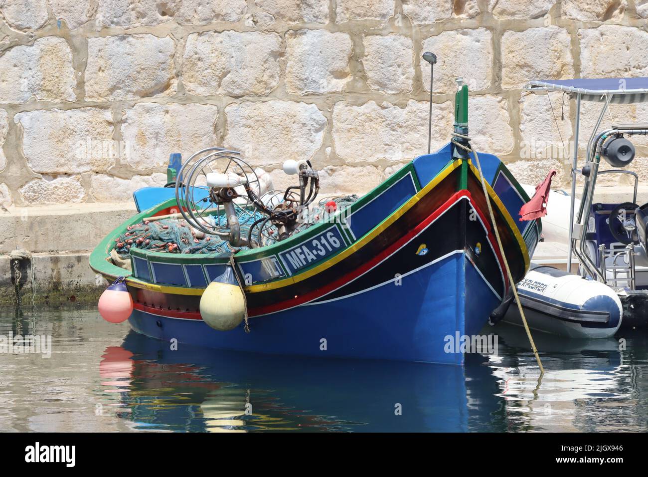 A traditionally painted Maltese Luzzu, moored in the marine at Marsalforn, Gozo, Malta Stock Photo