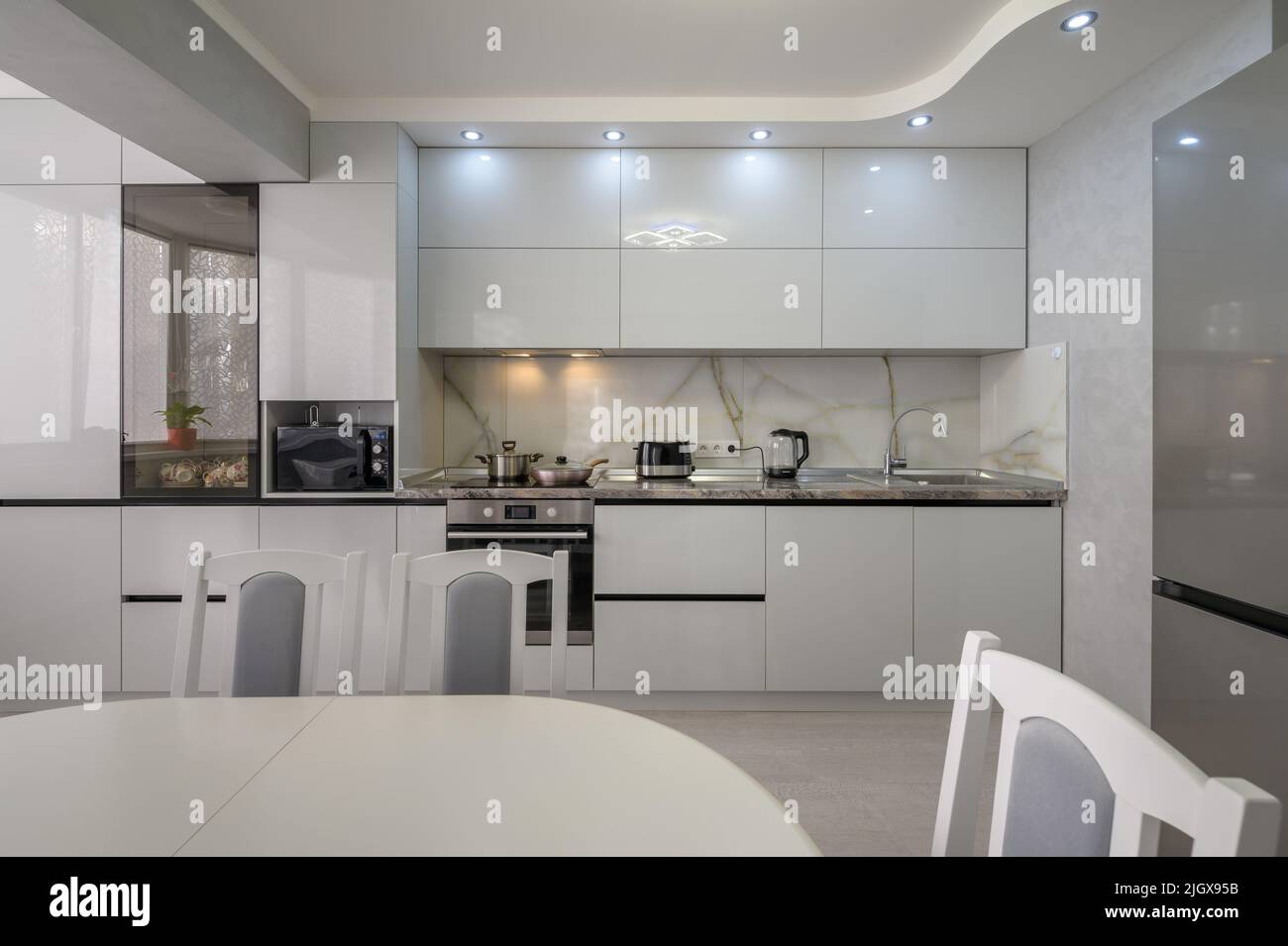 Interior of modern trendy white kitchen, front view Stock Photo - Alamy