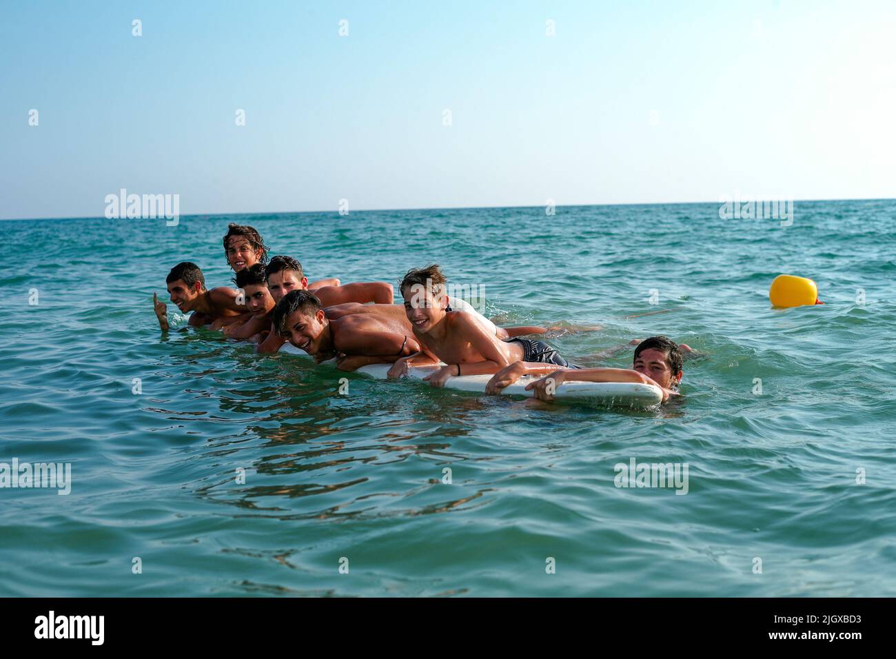 Young friends are basking in the sea on italian beach. Stock Photo