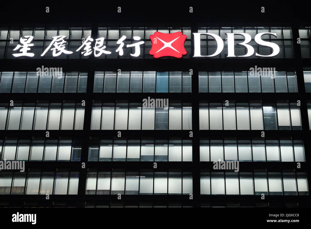 Shanghai,China-Feb.8th 2022: facade of DBS Bank company office building and logo at night. A Singaporean banking and financial services corporation Stock Photo