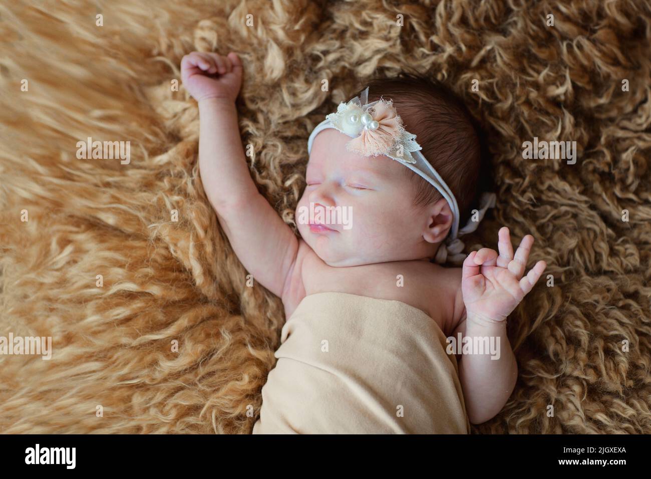 Cute newborn baby sleeping on brown fur blanket. Baby goods packaging