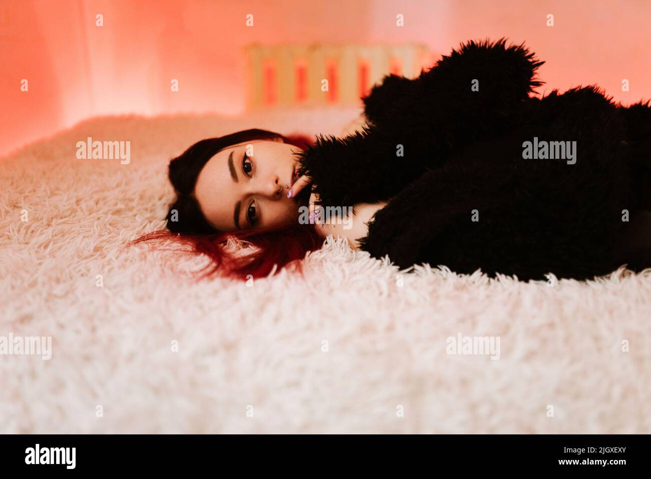 Portrait Of Beautiful Woman Lying On Bed Stock Photo