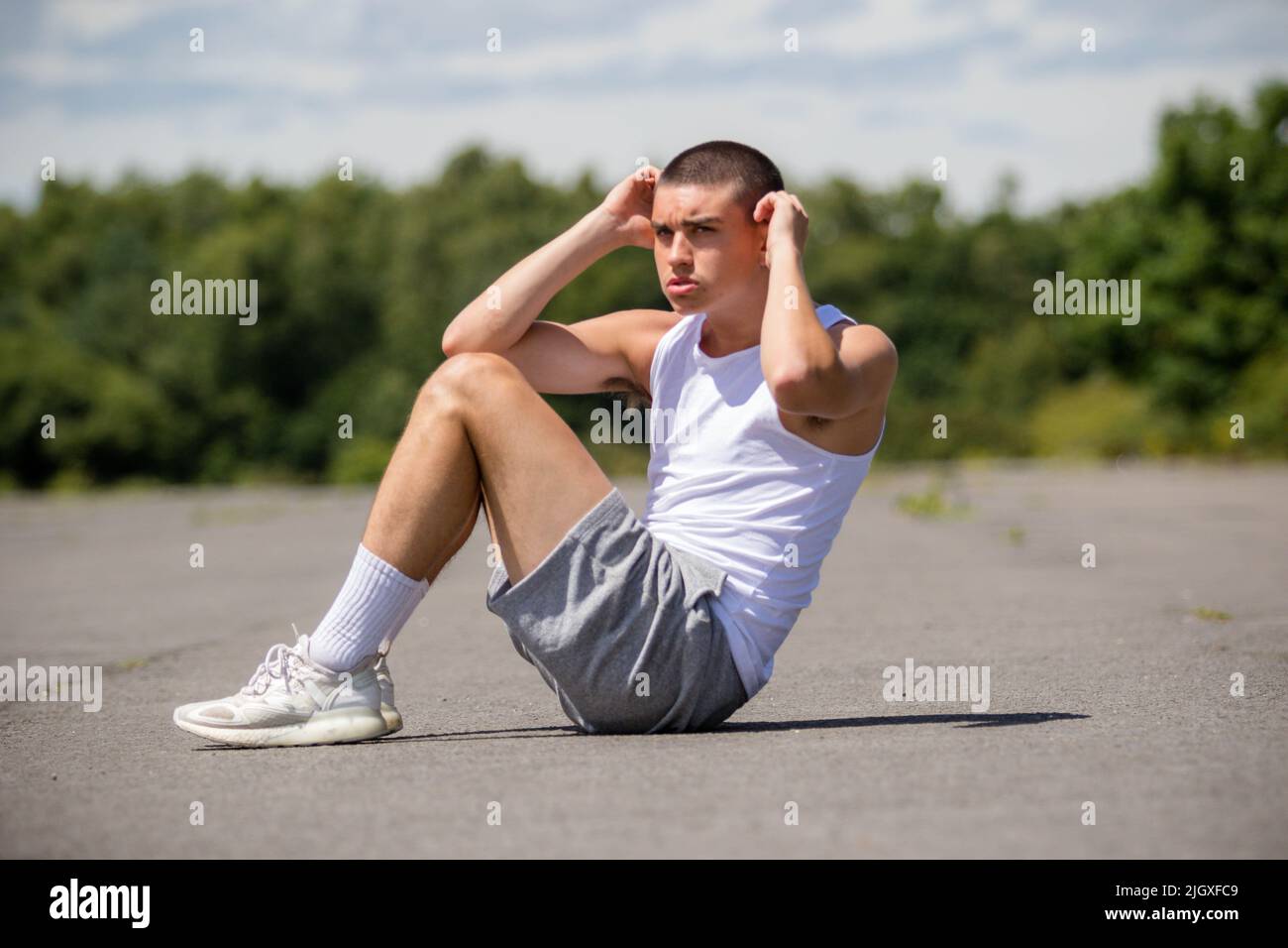 A Nineteen Year Old Teenage Boy Doing Situps In A Public Park Stock ...