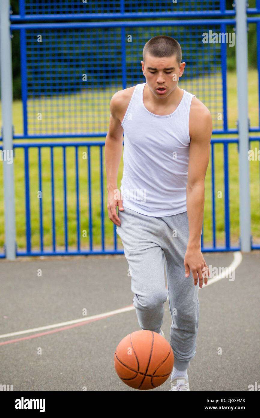 A Year Old Teenage Boy Playing Basketball in A Public Park