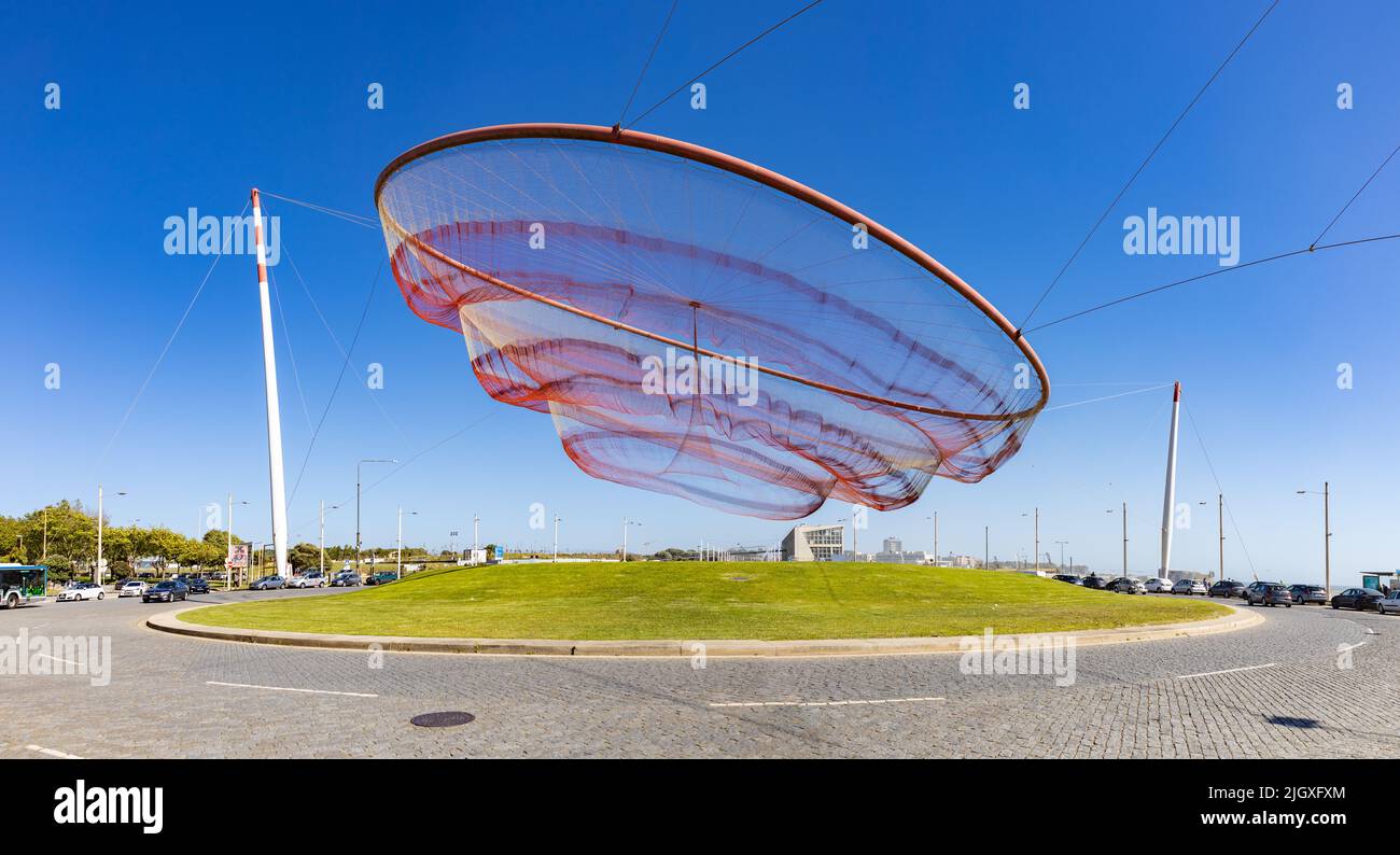 A picture of the dynamic sculpture She Moves, created by Janet Echelman in 2005. Also known as the Rotunda da Anémona (Anemone Roundabout). Stock Photo