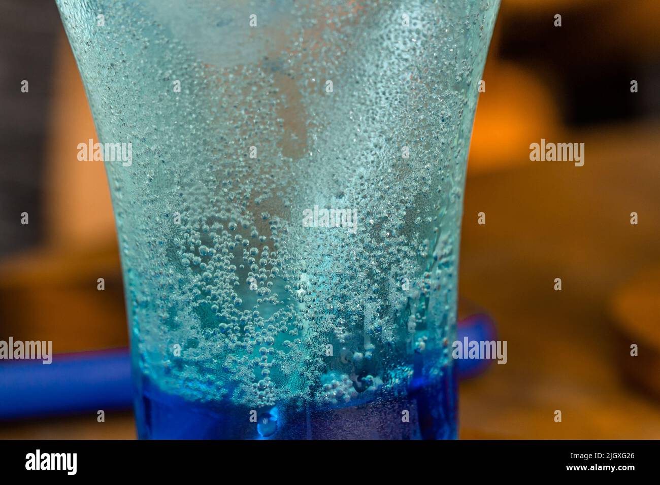 Bubbles and dew clinging to the glass of cold drink, refreshing blue