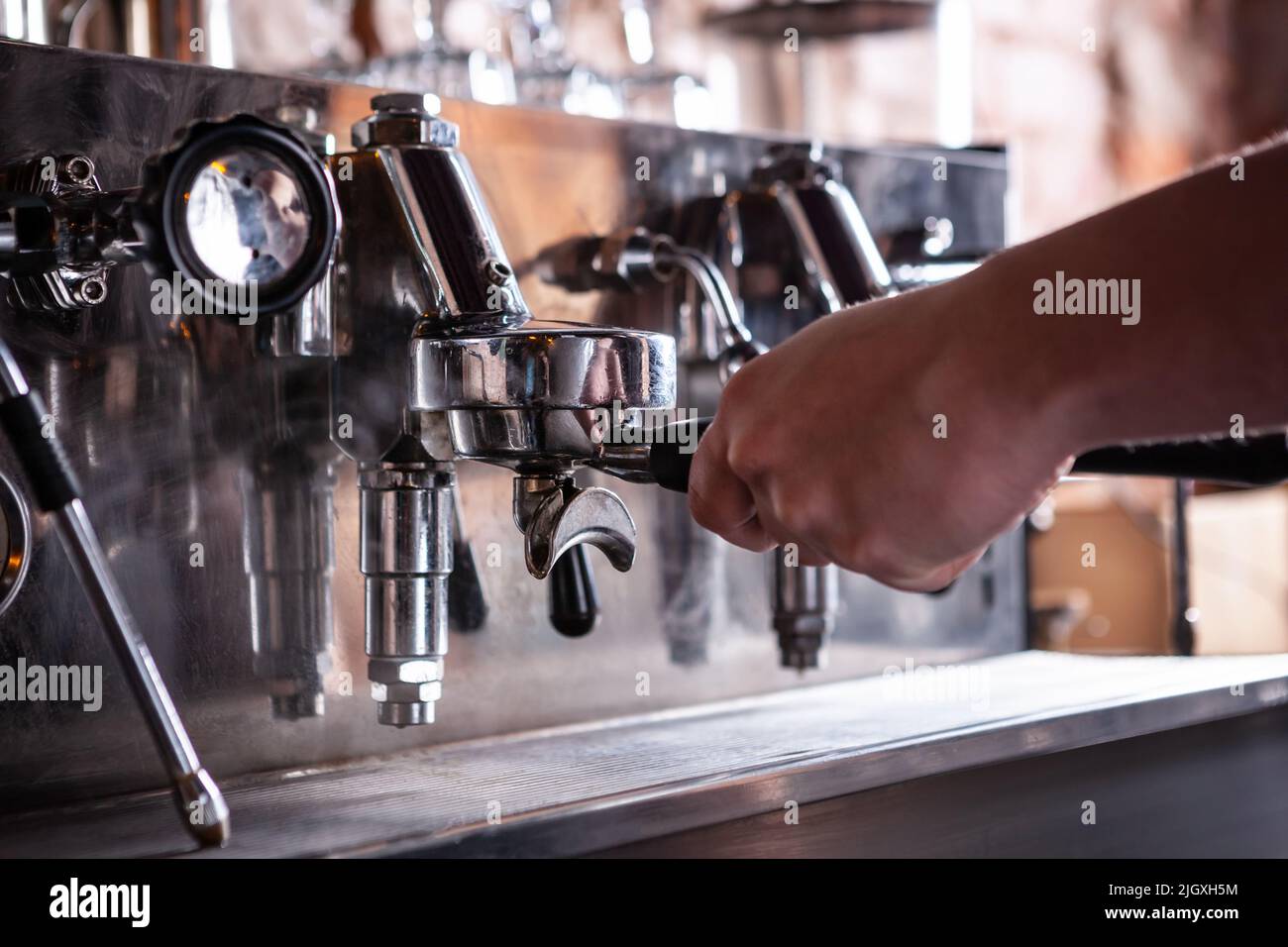 Close up of barista warming up espresso coffee machine. Stock Photo