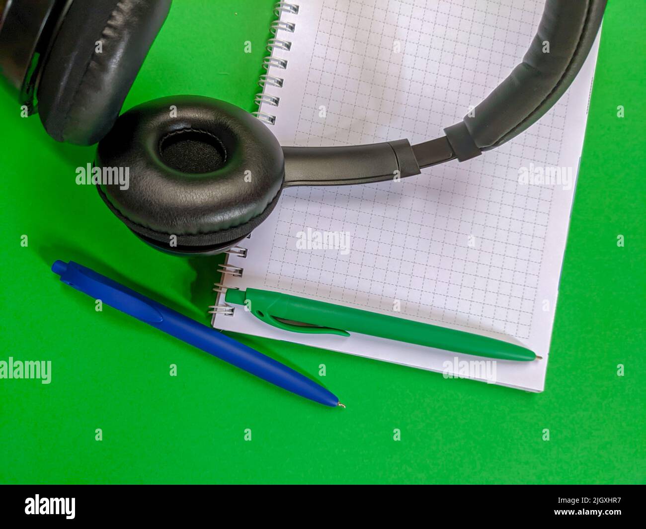 Headphones with notebook and pens Stock Photo