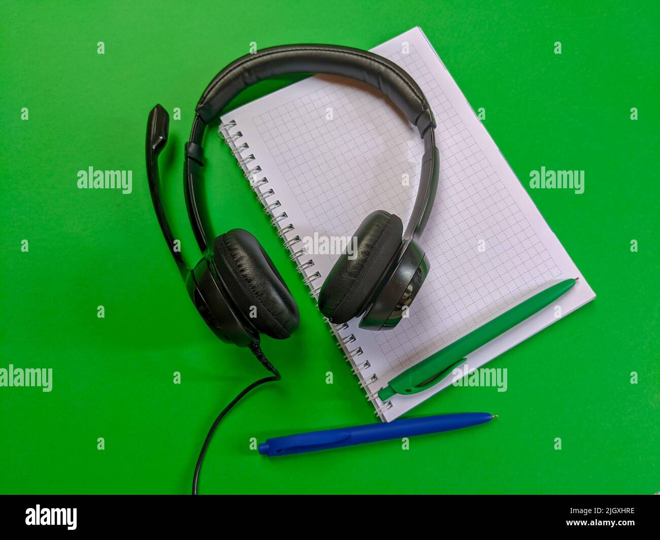 Headphones with notebook and pens Stock Photo