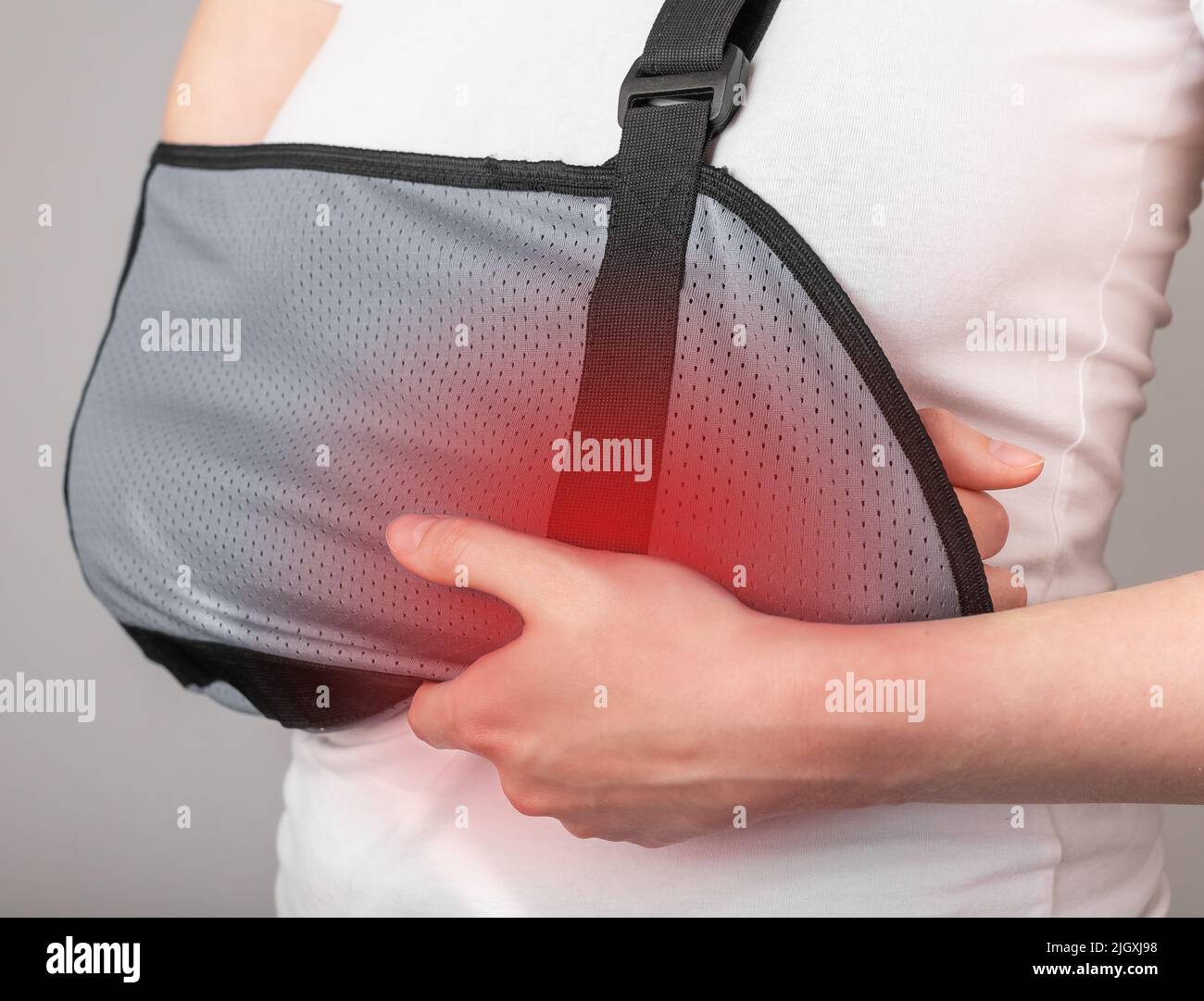Woman wearing sling to support injured forearm, wrist with red point