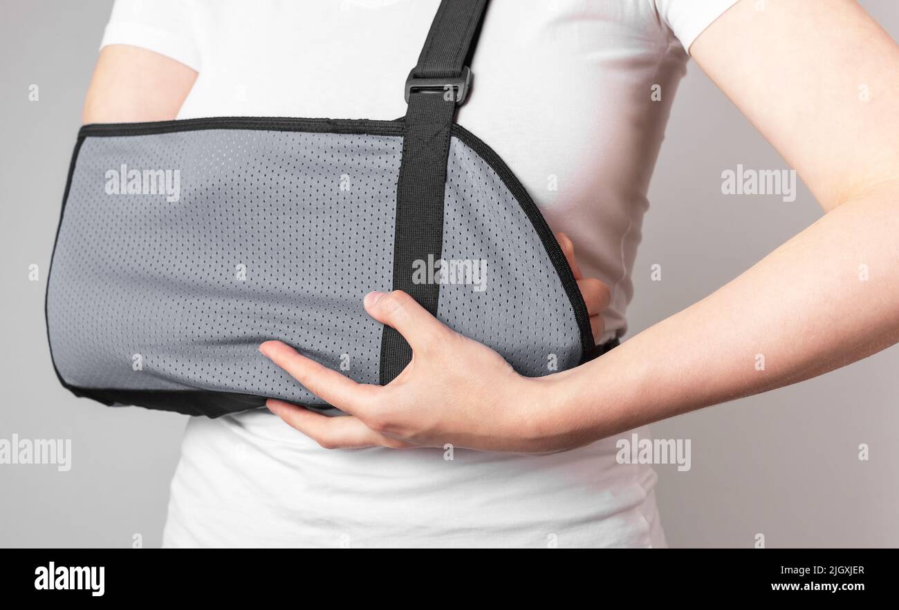 Woman wearing sling to protect painful forearm, wrist. Arm trauma