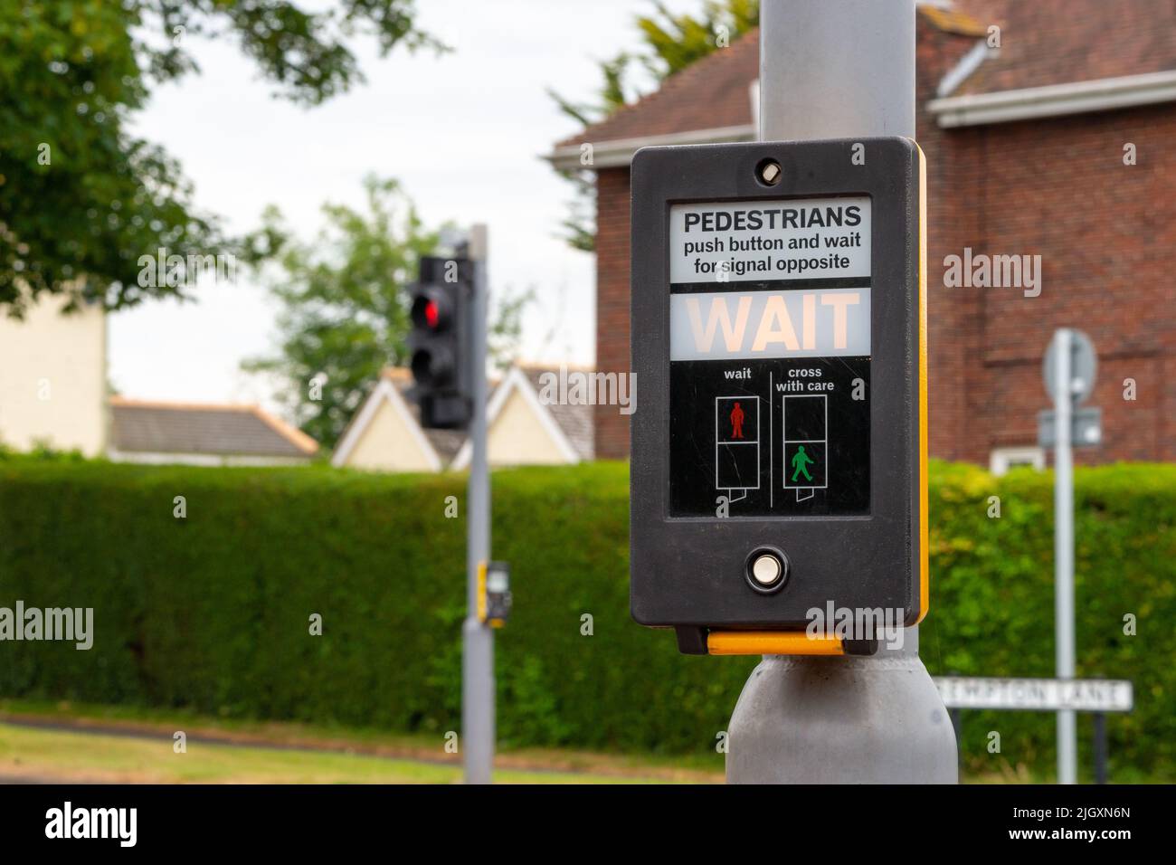 Pelican (historically Pelicon) crossing on a UK road. Pedestrians push button and wait for signal opposite Stock Photo