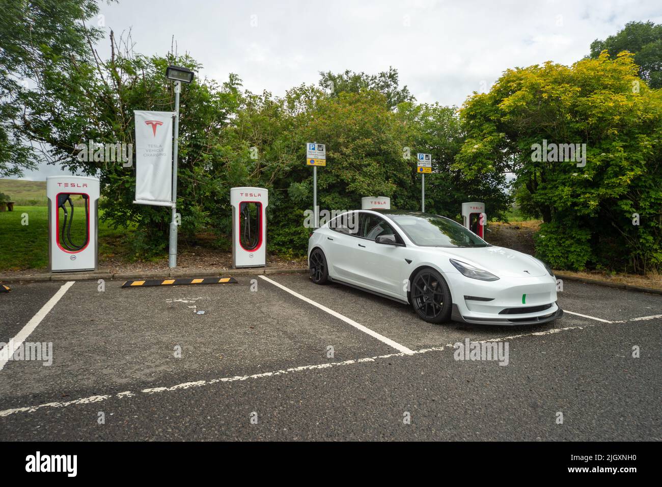 Tesla Supercharger charging point with Tesla car parked, Break
