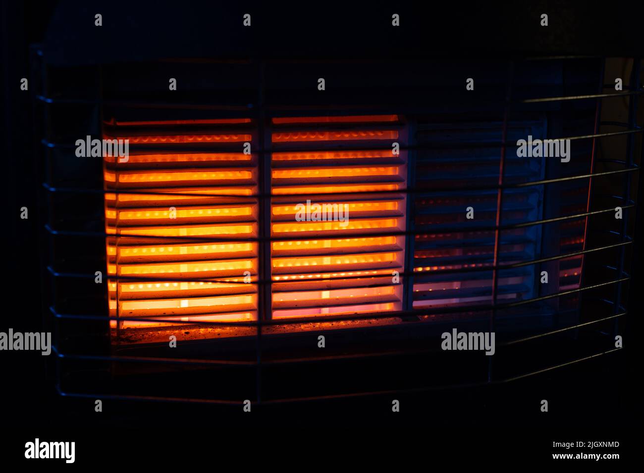 Indoor Gas Heater, radiant outset gas fire running with two out of three burners active Stock Photo