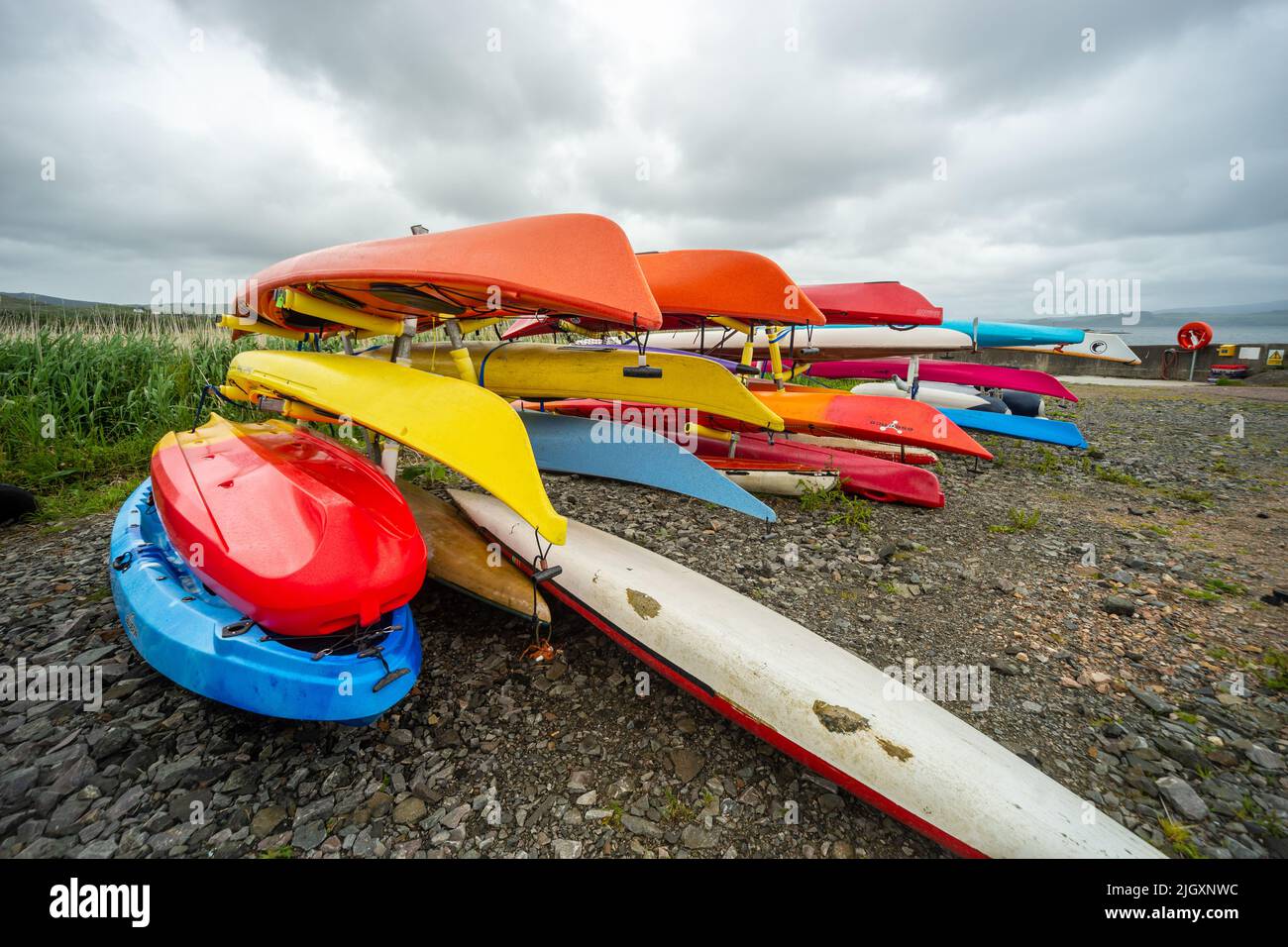 Colourful kayaks on the shore at Kilchoan Jetty, Scotland, UK Stock Photo