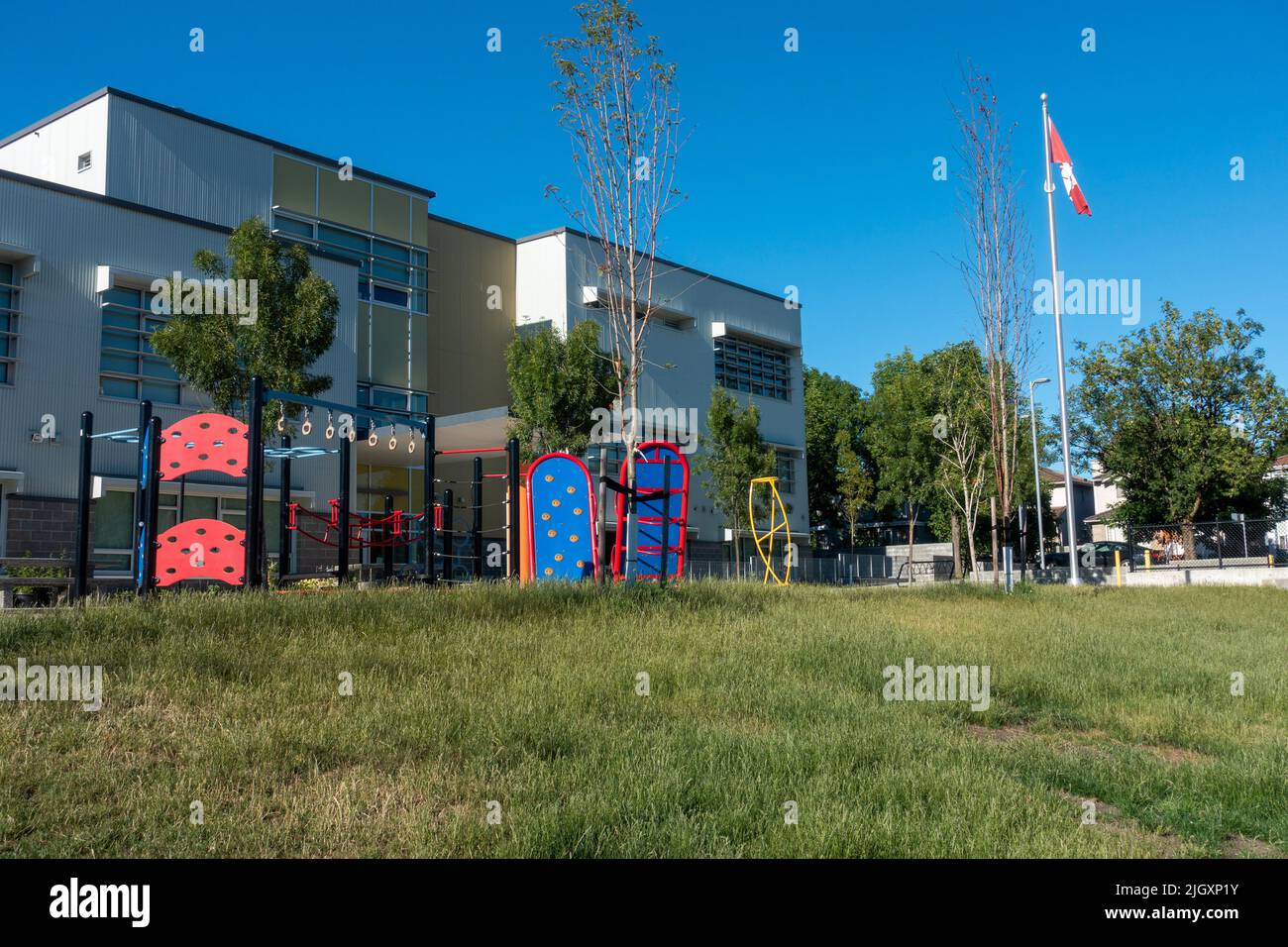 Modern elementary school building with playground equipment Stock Photo