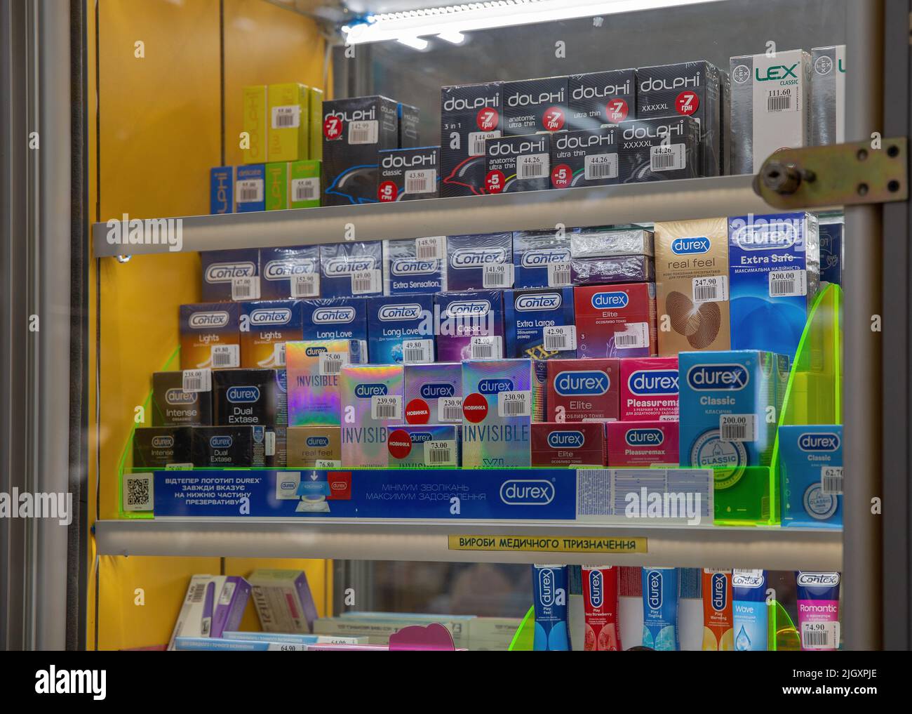 Mariupol, Ukraine - July 15, 2021: Pharmacy shelves full of different condoms products closeup. Boxes arranged in windows shelves. Stock Photo