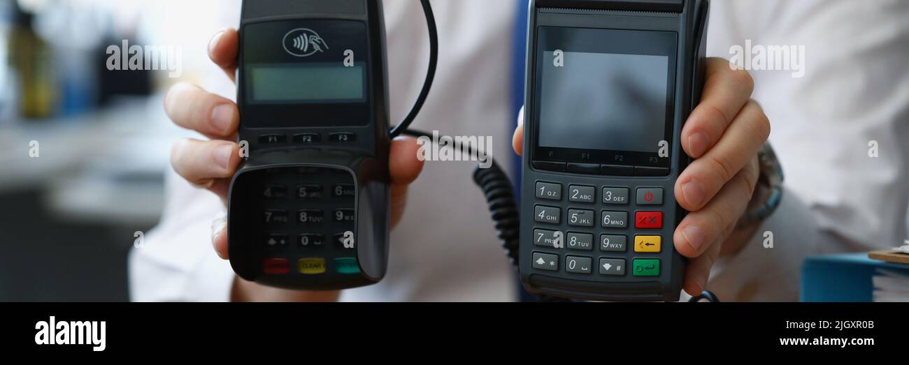 Man hold different models of credit card reader machines for cashless