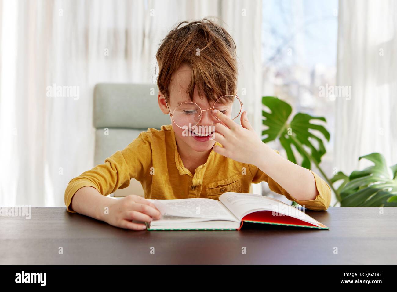 Smart boy reading book and smiling daytime Stock Photo