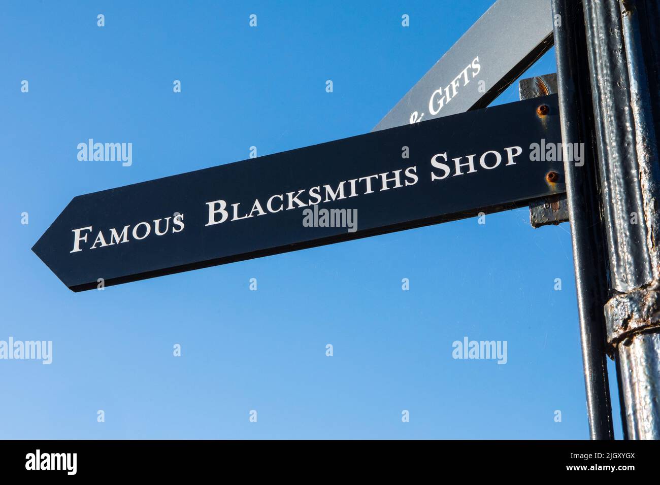Gretna Green, Scotland - October 15th 2021: A signpost pointing visitors to the direction of the Famous Blacksmiths Shop in Gretna Green, Scotland. Stock Photo