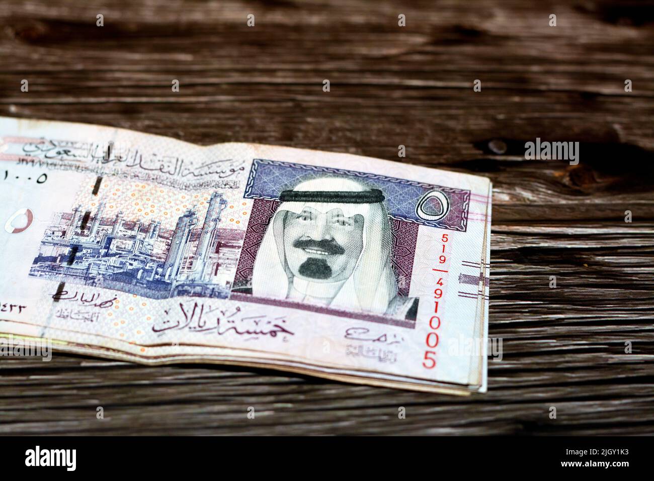 Stack of Saudi Arabia 5 SAR five Saudi riyals cash money banknote with the photo of king Abdullah Bin AbdulAziz Al Saud and Ras Tanura oil refinery is Stock Photo