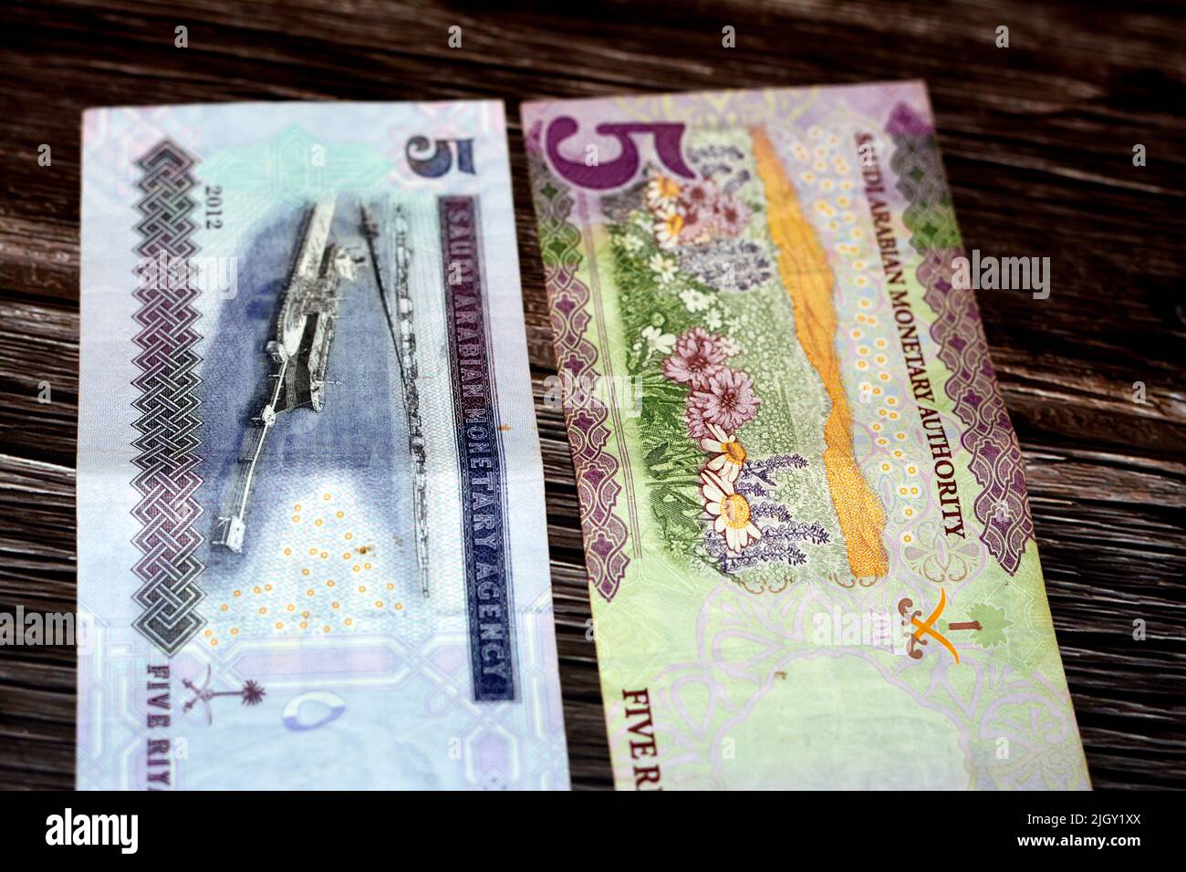 Saudi Arabia 5 SAR five Saudi riyals cash money banknote features flowers and Ras Tanura tanker loading terminal, Jubayl Port, Eastern Province isolat Stock Photo