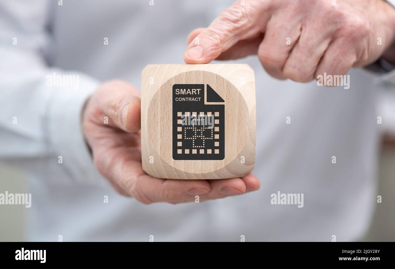 Hand holding a wooden cube with symbol of smart contract concept Stock ...