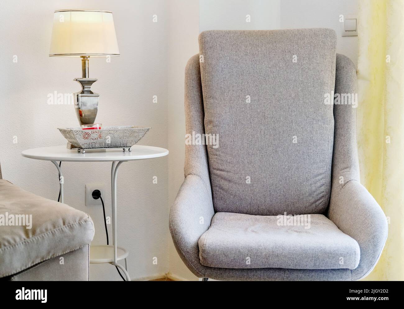 A grey modern cozy armchair in a living room Stock Photo - Alamy