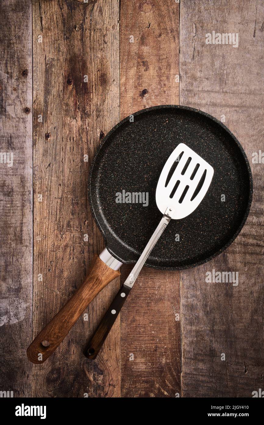 Flat large pancake baking pan and kitchen steel spatula, wood