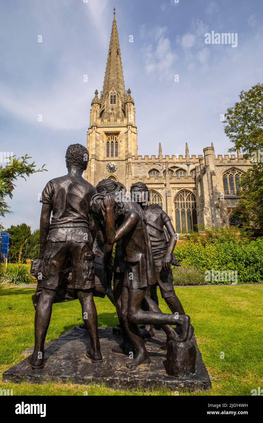 Essex, UK - September 6th 2021: The Children of Calais sculpture in the historic market town of Saffron Walden in Essex, UK.  The historic St. Marys c Stock Photo