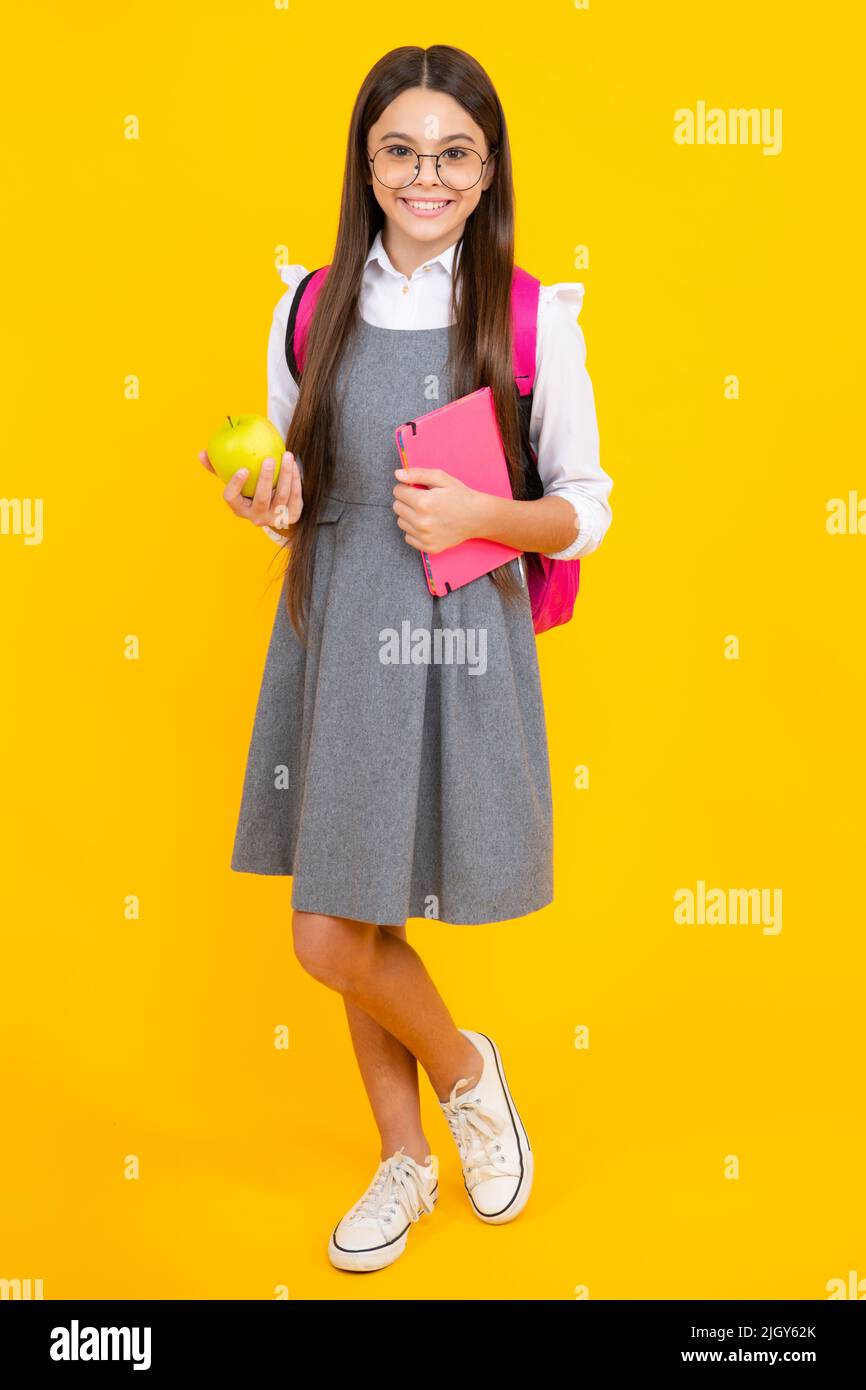 Back to school. Teenage school girl with bag hold apple and book, ready