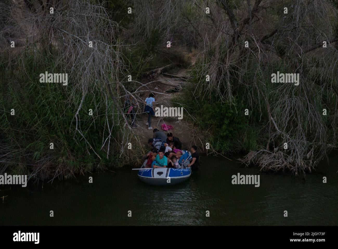 Migrants from Central and South America, looking to surrender to immigration officials, exit a raft after being smuggled across the Rio Grande river into the United States from Mexico in Roma Creek, Texas, U.S., July 12, 2022.  REUTERS/Adrees Latif Stock Photo
