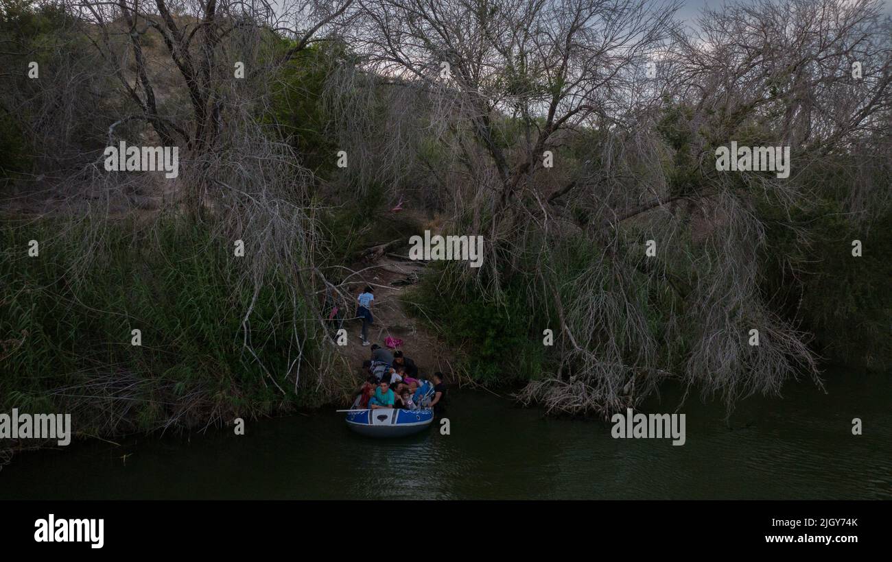 Migrants from Central and South America, looking to surrender to immigration officials, exit a raft after being smuggled across the Rio Grande river into the United States from Mexico in Roma Creek, Texas, U.S., July 12, 2022.  REUTERS/Adrees Latif Stock Photo
