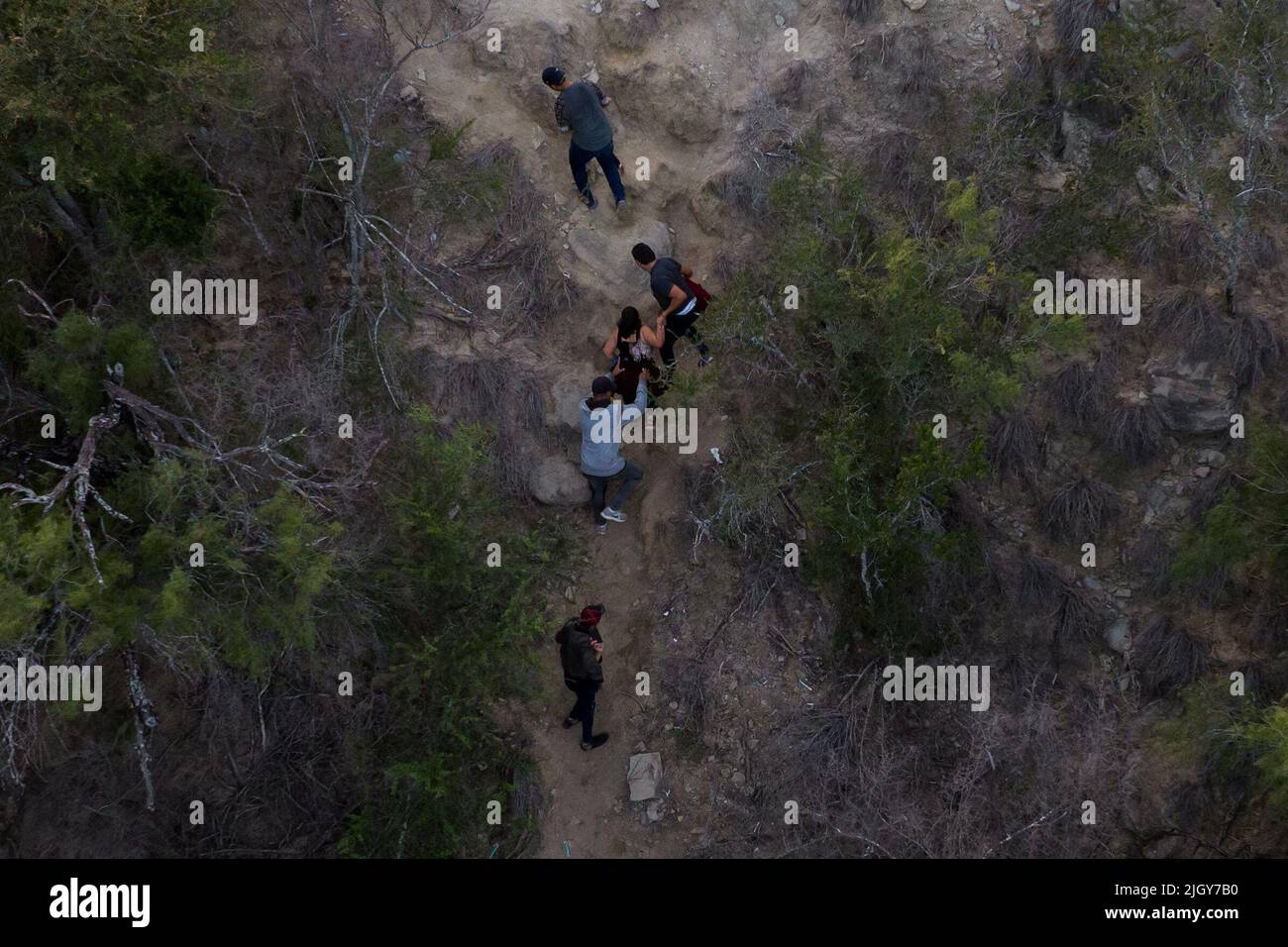 Migrants from Central and South America, looking to surrender to immigration officials, climb a bank after being smuggled across the Rio Grande river into the United States from Mexico in Roma Creek, Texas, U.S., July 12, 2022.  REUTERS/Adrees Latif Stock Photo