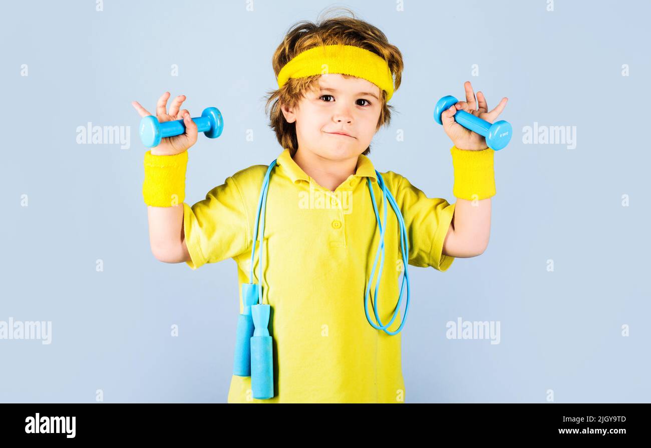 Boy with jumping rope and dumbbells. Fitness kid. Sport. Childhood activity. Child sportsman. Stock Photo