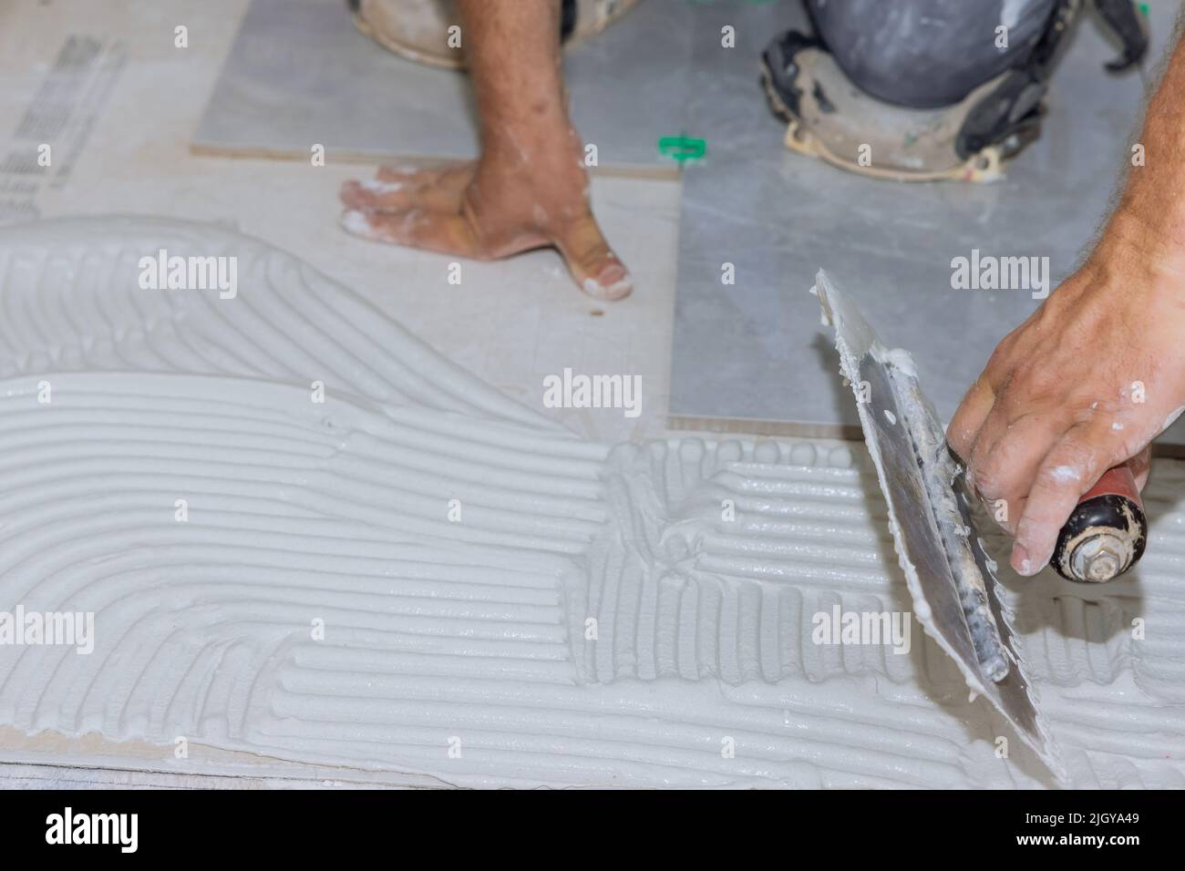 Adding wet mortar to the bathroom floor before applying tiles puts