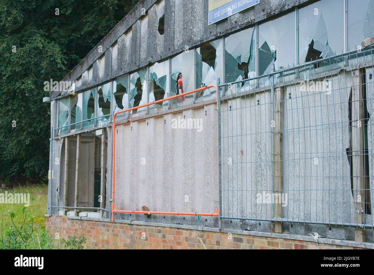 A derelict and abandoned building with broken glass windows in a forest ...