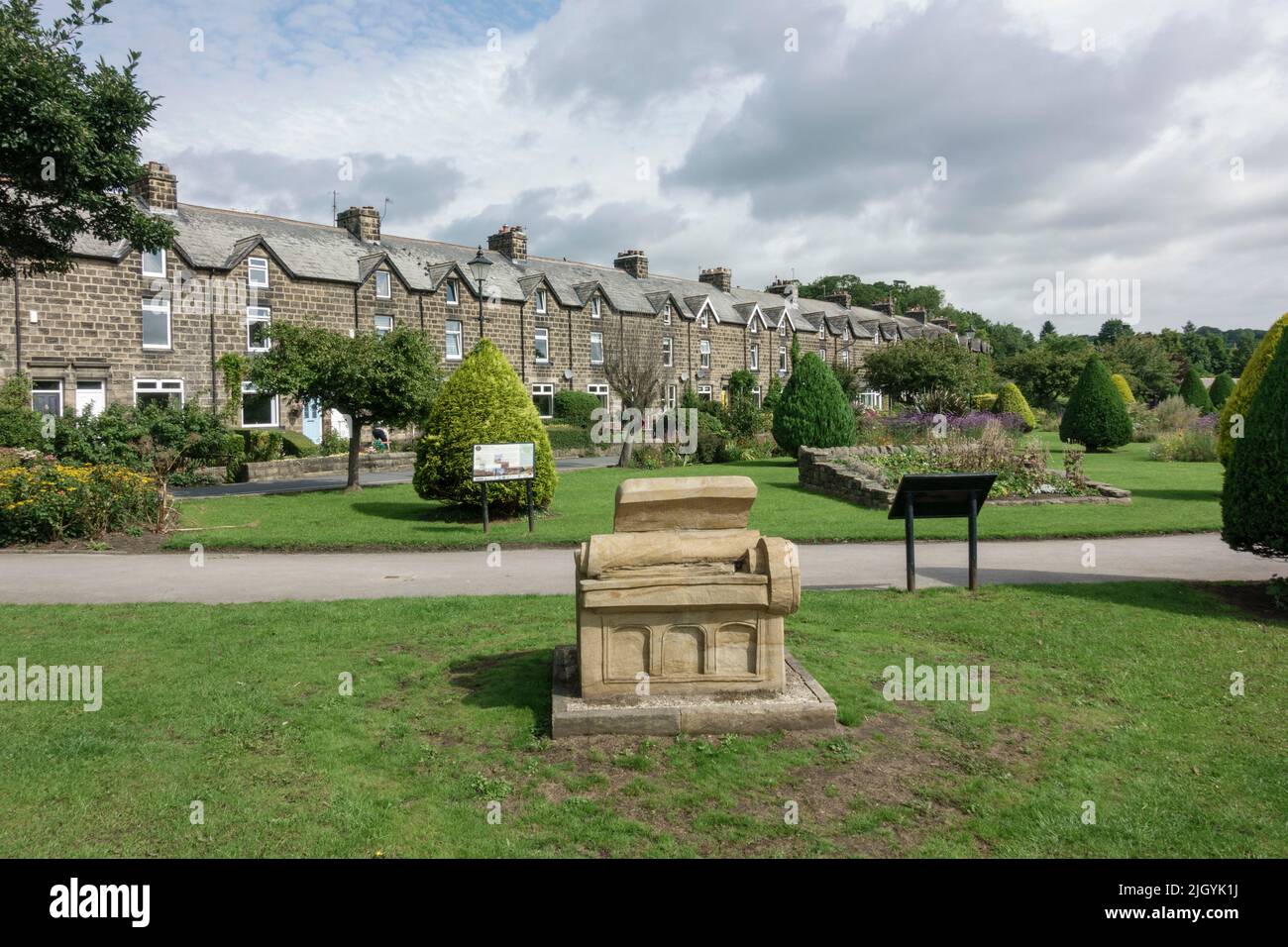 'The 3Rs – Homage to the Wharfedale Press' sandstone sculpture beside the River Wharfe and stone cottages, Otley, West Yorkshire, UK. Stock Photo